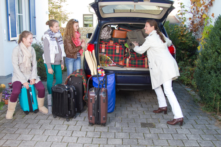 a group of people standing on top of a suitcase