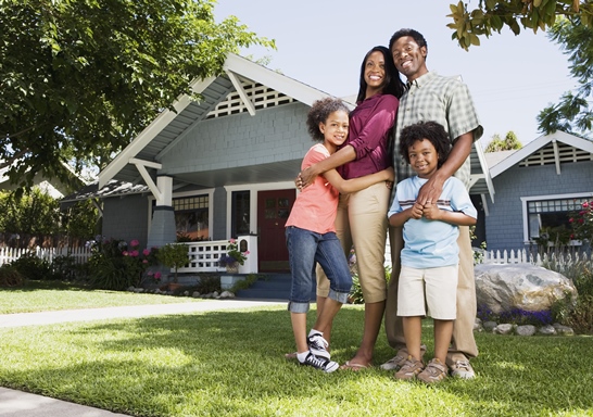 a family standing in front of a house