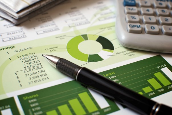 a close up of pen calculator chart graphs work